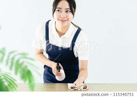 穿著圍裙擦桌子的女人 115340751