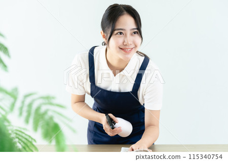穿著圍裙擦桌子的女人 115340754