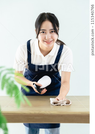 穿著圍裙擦桌子的女人 115340766