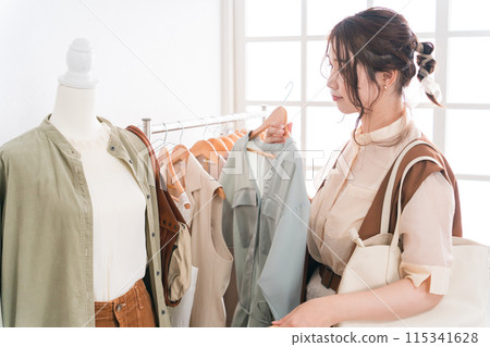 Young Asian woman choosing clothes at a clothing store/apparel shop Young Asian woman choosing clothes at a clothing store/apparel shop 115341628