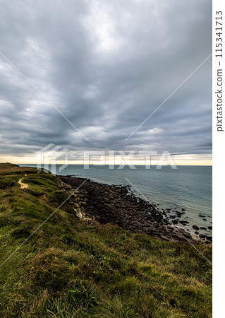 Coastal Cliff View with Dramatic Cloudy Sky and Rocky Shore is perfect for outdoor adventure 115341713
