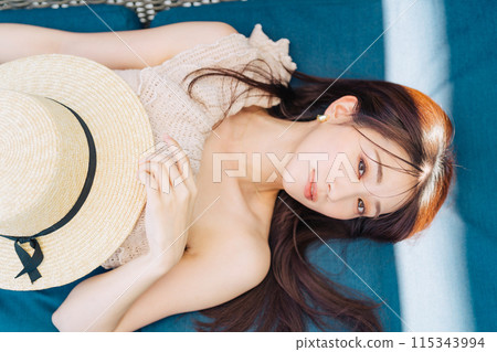 A woman in a swimsuit relaxing at a resort 115343994