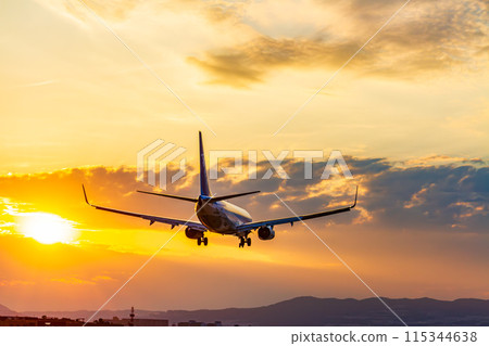 飛機降落在夕陽的天空 115344638