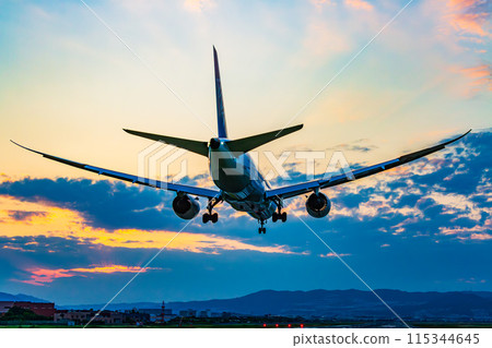 Airplane landing in the sunset 115344645