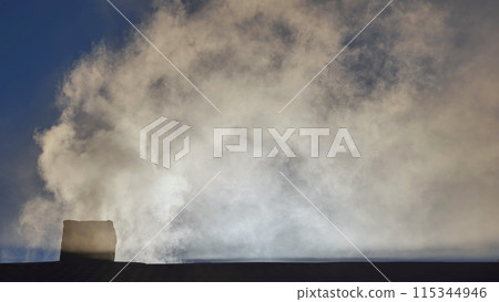 Silhouette of smoke against the sun from the chimney of a village house. Silhouette of smoke against the sun from the chimney of a village house. 115344946
