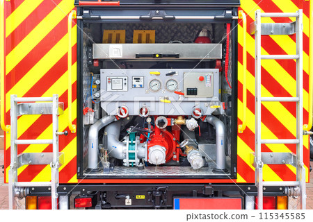 Close-up view of the pumping unit compartment from the rear of a fire truck. Close-up view of the pumping unit compartment from the rear of a fire truck. 115345585