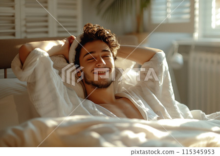 Happy Man Waking Up In Bed With Sunshine Streaming In Through The Window 115345953