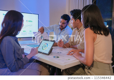 diversity team discusstion about esg and eco friendly system planning in sustainable green office at night 115346442