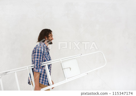 Man Carrying Ladder During Home Renovation Project Man Carrying Ladder During Home Renovation Project 115347174