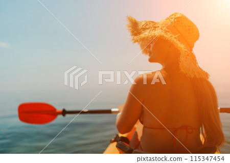 Woman in kayak back view. Happy woman with long hair in a swimsuit and hat floating in kayak on the sea. Summer holiday vacation. Summer holidays vacation at sea. Woman in kayak back view. Happy woman with long hair in a swimsuit and hat floating in kayak on the sea. Summer holiday vacation. Summer holidays vacation at sea. 115347454