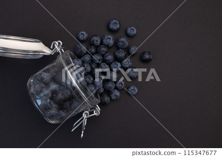 blueberries in glass jar isolated on black 115347677