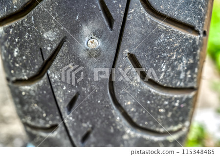 A screw got stuck in the rear tire of the motorcycle, causing a puncture 115348485