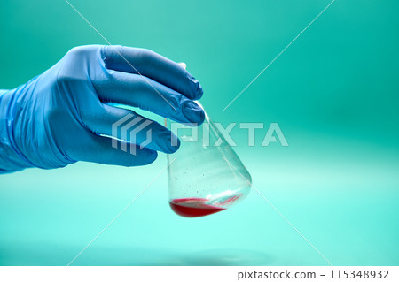 Unrecognizable scientist holding titration flask in laboratory 115348932