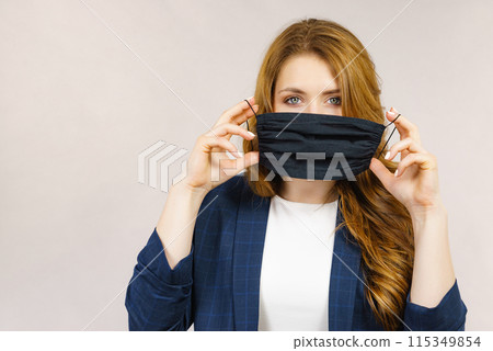 Woman using protective face mask. Woman using protective face mask. 115349854