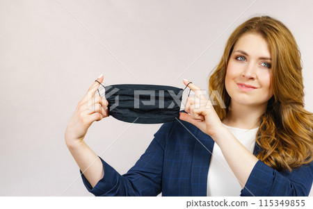 Woman shows black protective face mask. Woman shows black protective face mask. 115349855