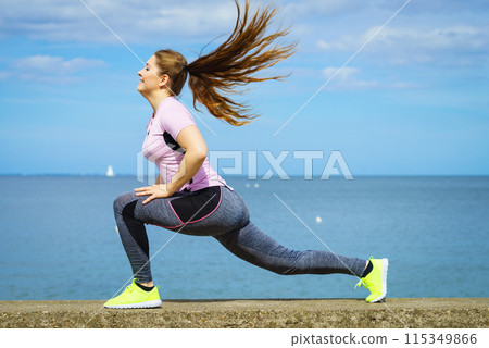 Woman stretching legs next to sea 115349866