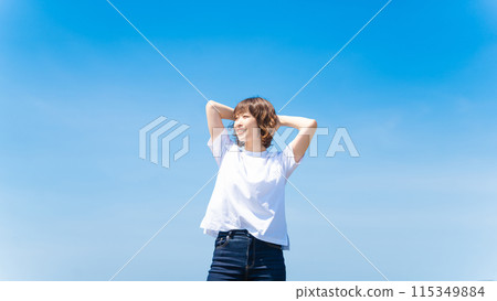 Summer blue sky and a smiling woman in a white T-shirt 115349884