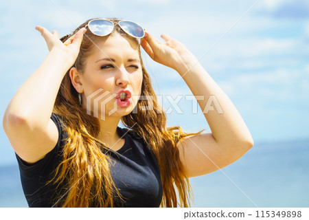 Happy teen woman against clouds 115349898