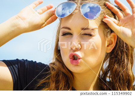 Happy teen woman against clouds 115349902