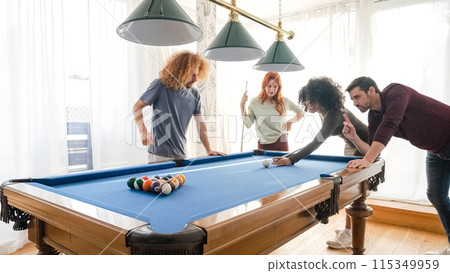 Multiethnic friends playing pool together in game room at home Multiethnic friends playing pool together in game room at home 115349959