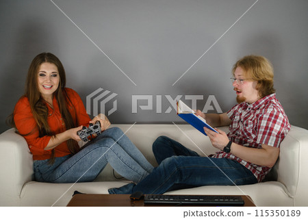 Woman playing games man reading book 115350189