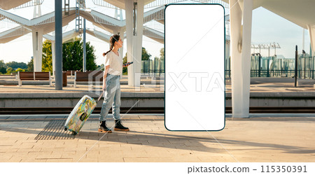 Web banner of travel. Young woman walking with her luggage and using cellphone. Big smartphone with mock up and copy space. Concept of modern travel and vacation Web banner of travel. Young woman walking with her luggage and using cellphone. Big smartphone with mock up and copy space. Concept of modern travel and vacation 115350391