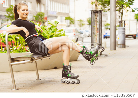 Young woman sitting wearing roller skates 115350507