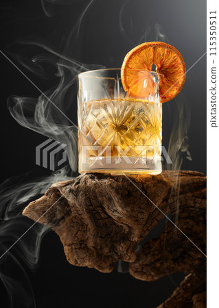 Smoked old fashioned cocktail with ice and dried orange slice. Smoked old fashioned cocktail with ice and dried orange slice. 115350511