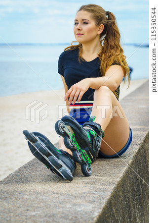 Girl wearing roller skates on seaside 115350544