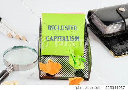 Business inclusive capitalism concept. Copy space. Words Inclusive capitalism on a green sticker next to the business accessories 115351057