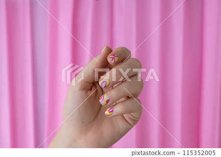 Pastel softness colorful manicured nails on pink background. Woman showing her new summer manicure in colors of pastel palette. Simplicity decor fresh spring vibes earth-colored neutral tones 115352005