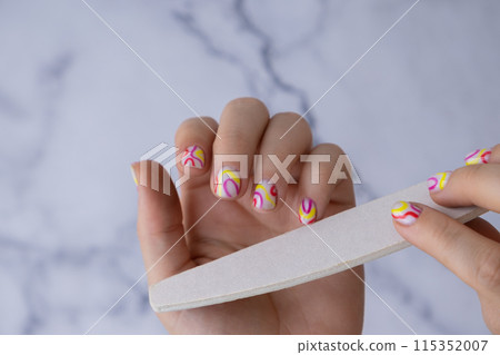 Manicure tools Pastel softness colorful manicured nails. Woman showing her new summer manicure in colors of pastel palette. Simplicity decor fresh spring vibes earth-colored neutral tones 115352007