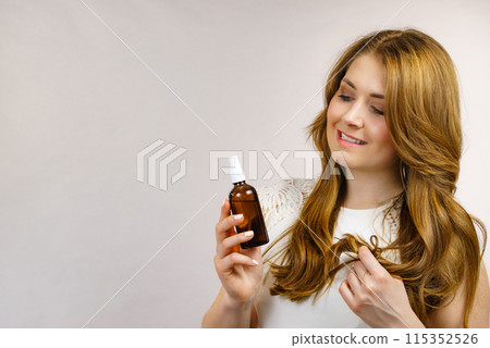 Woman applying hair cosmetic 115352526