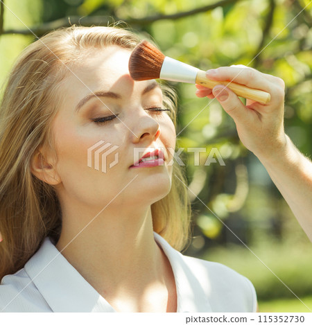 Portrait of woman getting makeup done outside Portrait of woman getting makeup done outside 115352730