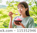 A woman eating shaved ice in hot summer 115352946