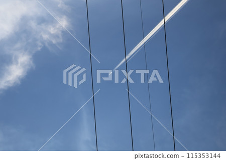A view of power lines, white clouds, a white airplane, a contrail, and a blue sky A view of power lines, white clouds, a white airplane, a contrail, and a blue sky 115353144
