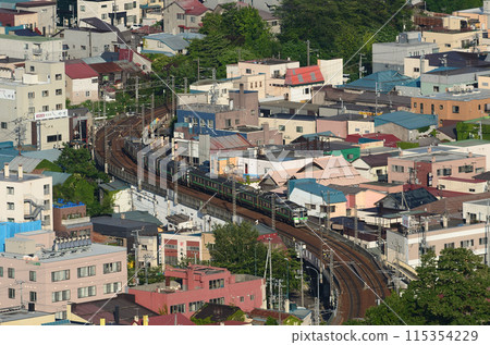 沐浴在夕陽下的函館本線的普通列車穿過小樽市的S曲線。 沐浴在夕陽下的函館本線的普通列車穿過小樽市的S曲線。 115354229
