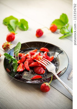 fresh fruit salad of ripe strawberries on a light wooden table fresh fruit salad of ripe strawberries on a light wooden table 115354782