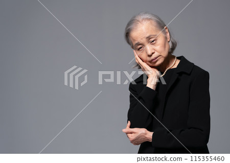 Senior woman in mourning clothes worries 115355460
