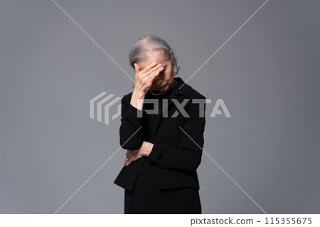 Senior woman in mourning clothes covering her face Senior woman in mourning clothes covering her face 115355675