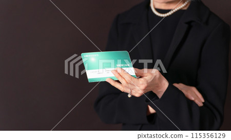 Senior woman in mourning clothes laments as she looks at her bankbook Senior woman in mourning clothes laments as she looks at her bankbook 115356129