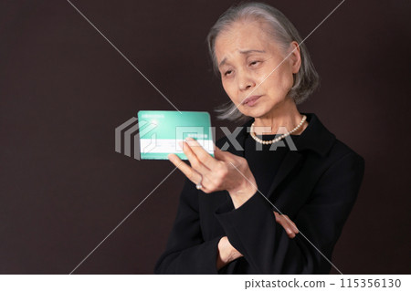 一位身穿喪服的老婦人看著她的銀行存摺，感嘆道 115356130