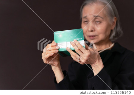 一位身穿喪服的老婦人看著她的銀行存摺，感嘆道 115356140