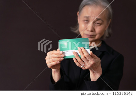 一位身穿喪服的老婦人看著她的銀行存摺,感嘆道 一位身穿喪服的老婦人看著她的銀行存摺,感嘆道 115356142