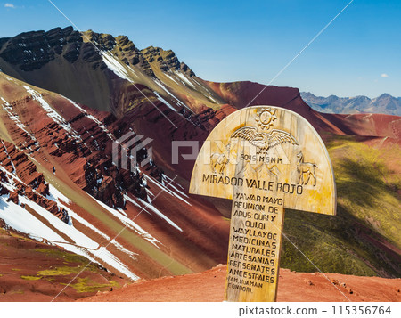 Red Valley with wooden sign in foreground, Cusco region, Peru 115356764