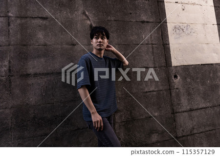 Young man leaning against a wall Young man leaning against a wall 115357129