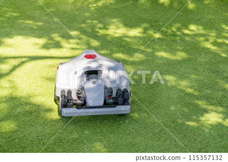 Autonomous robot lawnmower on a green field. 115357132