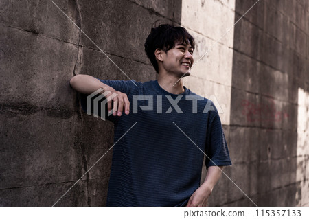 Men leaning against the wall 115357133