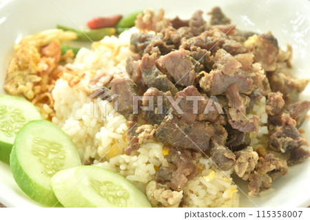 fried salty slice beef meat belly with crispy shallot and chili on rice couple cucumber in plate 115358007