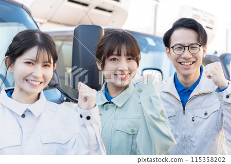 Three truck drivers, both male and female, wearing work clothes and posing with fist pumps Three truck drivers, both male and female, wearing work clothes and posing with fist pumps 115358202